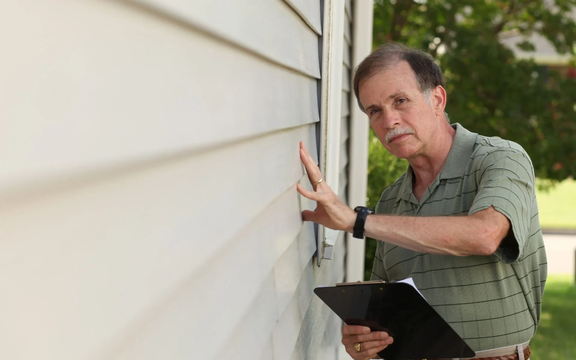 Home exterior siding being inspected after new siding installation