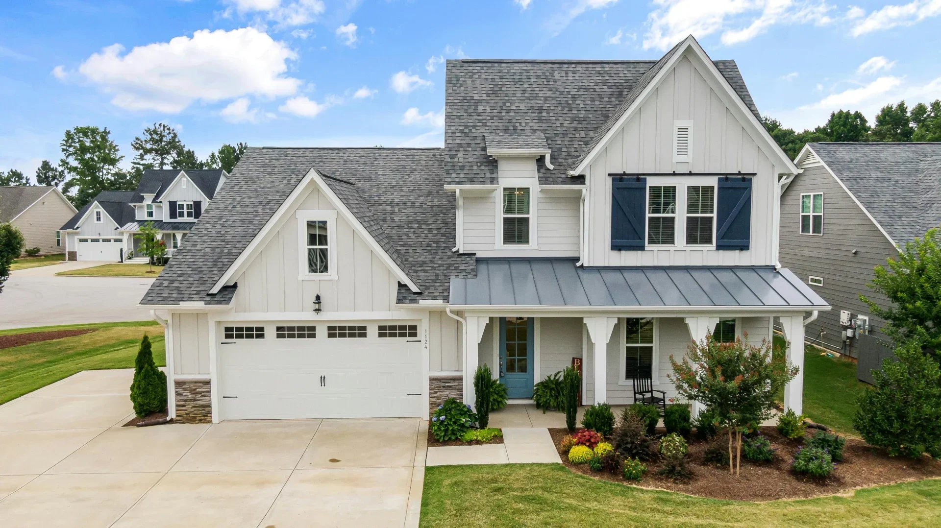 A large, grey roofed home with white siding, where homeowners can contact The Eavestrough Company