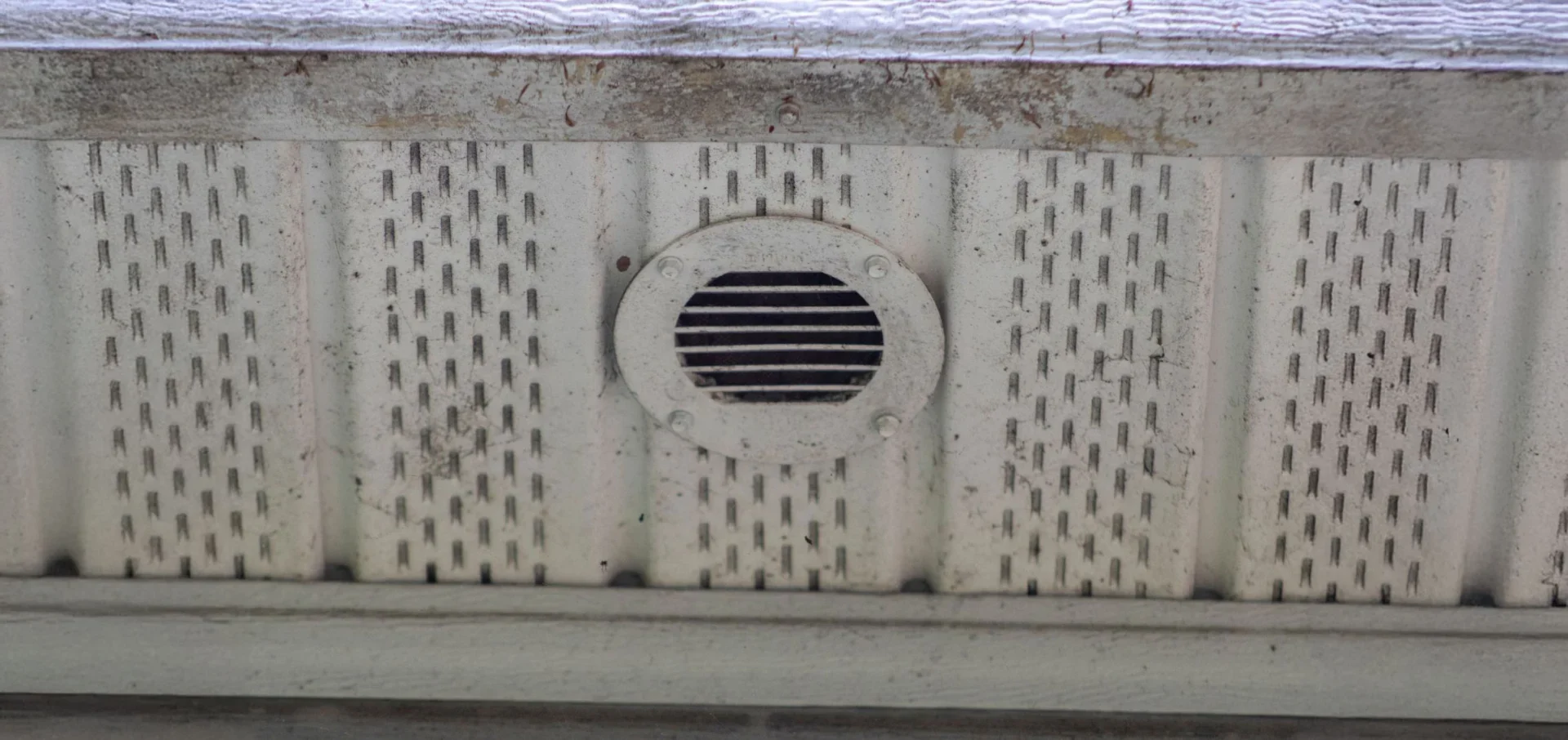 An up-close image of an old soffit installation that is molded, broken, and decaying