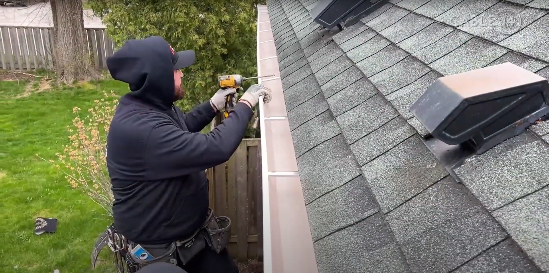 A The Eavestrough Company working screwing in hangers during an eavestrough installation