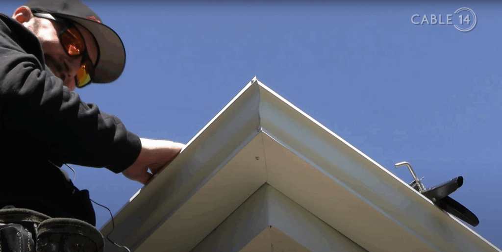 A closeup of a custom fit eavestrough corner being inspected